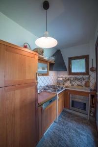 una cucina con armadi in legno e una luce a ciondolo di Villa Gia a Stresa