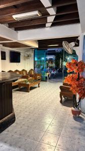 una sala de estar con sofás, TV y una planta en Relax Guest House, en Patong Beach
