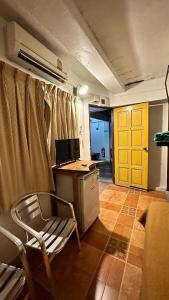 una oficina con escritorio, silla y puerta amarilla en Relax Guest House, en Patong Beach