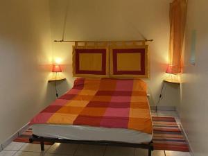 a bedroom with a colorful bed with two lamps at Charmant gîte rénové avec terrasse privative, jardin et parking - Animaux acceptés - FR-1-489-10 in Neuvy
