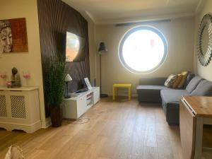 a living room with a blue couch and a window at Leeds city center apartment in Leeds