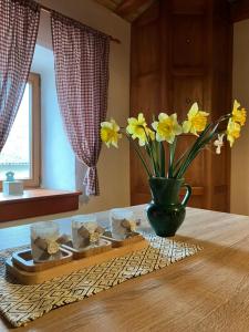 una mesa con un jarrón con flores amarillas. en ADORI, en Ilirska Bistrica