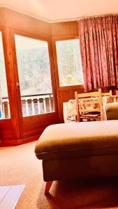 um quarto com uma cama, uma cadeira e 2 janelas em Apartement Morzine Avoriaz em Morzine