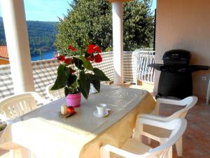 a table with a vase with a flower on a porch at Villa Luma Apartments in Labin