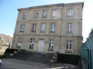 a large stone building with stairs in front of it at Studio dans charmante Bâtisse de Maître Compiégnoise in Compiègne
