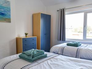 1 dormitorio con 2 camas, vestidor y ventana en Mere House en Morecambe