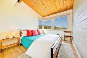 een slaapkamer met een bed en een houten plafond bij La Jolla Lookout in San Diego