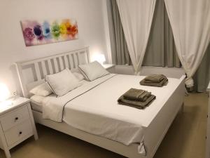 a bedroom with a white bed with two towels on it at Apartamento amplio y céntrico in Fuengirola