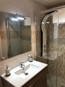 a bathroom with a sink and a shower and a mirror at Apartamento amplio y céntrico in Fuengirola