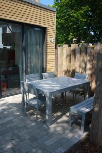 stół piknikowy, 2 krzesła i ławka w obiekcie Ferienhaus Buhne V w mieście Graal-Müritz