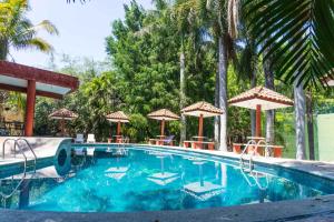 una piscina con sillas y sombrillas en Casa Caracol Armonia, en Xochitepec