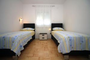een slaapkamer met 2 bedden en een raam bij Vila Stella in Tisno