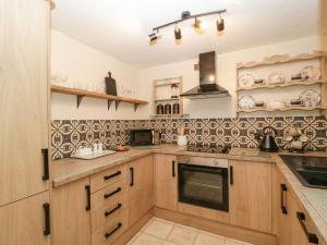 a kitchen with wooden cabinets and a stove top oven at Beau Hideaway in Dorchester