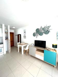 a living room with a tv and a table at Sun Beach 89 in Caleta De Fuste