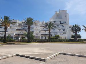 un grand bâtiment blanc avec des palmiers devant lui dans l'établissement Puerto Tomas Maestre, à San Javier