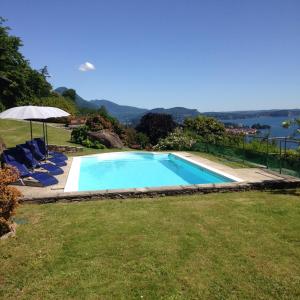 a swimming pool with chairs and an umbrella at Romantic Nido in Verbania