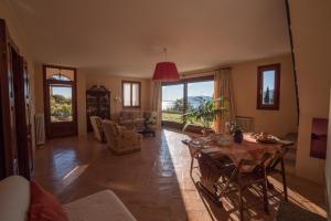 a living room with a table and chairs and windows at Romantic Nido in Verbania