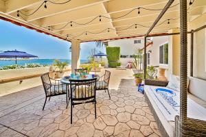 eine Terrasse mit Tisch und Stühlen sowie Strand in der Unterkunft On The Beach Casa in San Diego