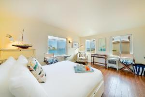 a bedroom with a large white bed and a desk at On The Beach Casa in San Diego