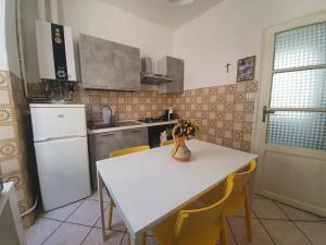 eine Küche mit einem weißen Tisch und gelben Stühlen in der Unterkunft Rosa&Mario Lake House in Verbania
