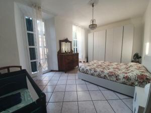 Schlafzimmer mit einem Bett, einer Kommode und Fenstern in der Unterkunft Rosa&Mario Lake House in Verbania