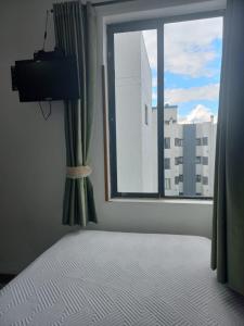 a bedroom with a bed and a large window at APARTA-HOTEL BADEN in Bogotá