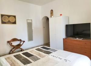 una camera con letto e TV su un comò di Lemon Casa con giardino a Monterotondo
