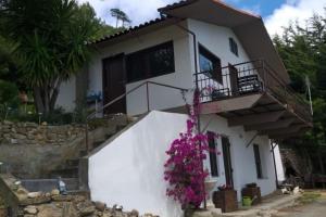 a white house with flowers on the side of it at Detached house with garden and sea view in Sanremo