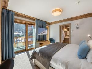 a bedroom with a large bed and a balcony at Chalet Méribel, 7 pièces, 12 personnes - FR-1-566-44 in Les Allues