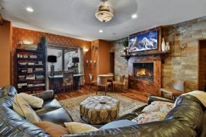 a living room with a leather couch and a fireplace at The Pearl of Park City in Park City +25 photos