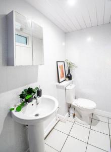 Baño blanco con aseo y lavamanos en Ashford House - By Sigma Stays en Etruria