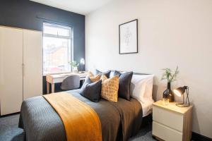 a bedroom with a bed and a table and a window at Ashford House - By Sigma Stays in Etruria