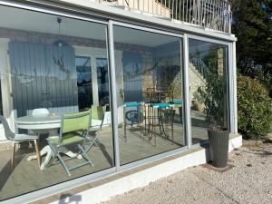 um jardim de Inverno com portas de vidro, uma mesa e cadeiras em Chez Pat et Dom em Aix-en-Provence