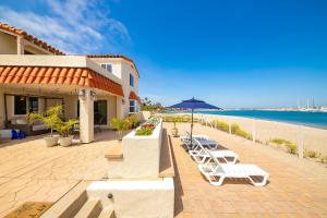 a group of lounge chairs and an umbrella on the beach at On The Beach Casita in San Diego