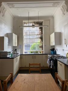 a kitchen with white cabinets and a window at Westbourne Place Rooms - by Clifton Short Lets in Bristol