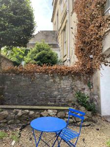 una mesa azul y una silla frente a una pared de piedra en Westbourne Place Rooms - by Clifton Short Lets, en Bristol