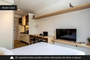 Zimmer mit einem Bett und einem Schreibtisch mit einem TV in der Unterkunft Smart Charlie Parque Augusta Mackenzie in São Paulo