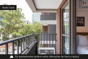Apartamento en condominio con balcón y cama en Smart Charlie Parque Augusta Mackenzie, en São Paulo