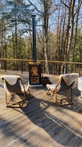 two chairs and a fire place on a deck at Stiefelburg Der Berghof in Nauendorf