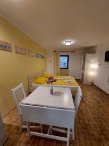a room with two beds and a table and chairs at Terra Apartments in Piran
