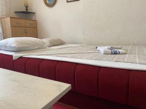 a bed in a room with a red and white mattress at Stan na dan Boljevac in Boljevac