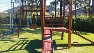 um parque infantil de madeira com um baloiço num quintal em Loft Condado em Sahy - Mangaratiba em Mangaratiba