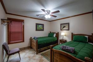 um quarto com 2 camas e uma ventoinha de tecto em Calcasieu Lodge em Hackberry