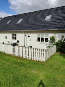 Rosengård في Hammel: منزل أبيض مع سياج خشبي أبيض