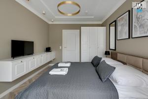 a bedroom with a bed and a flat screen tv at MS Apartments Rest 4.0 in Sopot