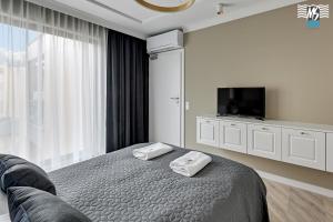 a bedroom with a bed with two towels on it at MS Apartments Rest 4.0 in Sopot