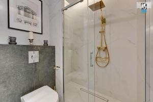 a bathroom with a glass shower with a toilet at MS Apartments Rest 4.0 in Sopot