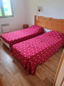 two beds in a room with a pink bedspread at Le Hameau des Ecrins Station 1800 in Puy-Saint-Vincent