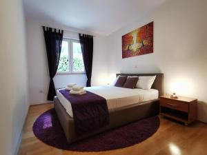 a bedroom with a large bed and a window at Apartment Zara in Dubrovnik