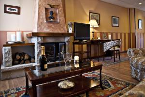 a living room with a fireplace and a bottle of wine at Hotel Doña Jimena in Villarcayo